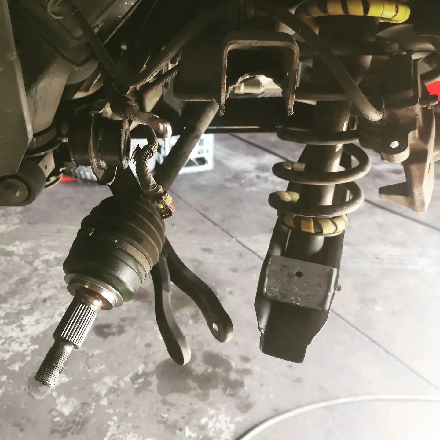 Front CV axle removed alongside coil-over strut during suspension work at S & A Automotive Cairns
