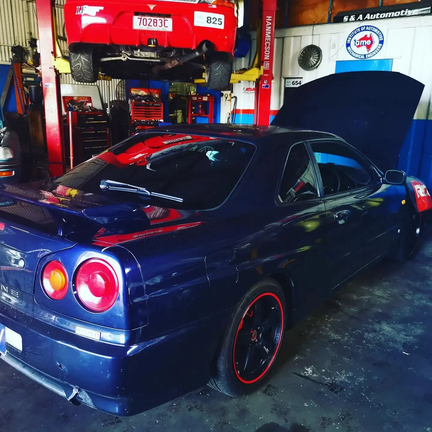 Nissan Skyline R34 in for service alongside a lifted Toyota at S & A Automotive in Portsmith, Cairns